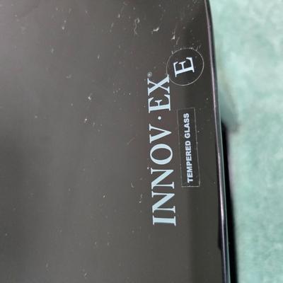 Innov-ex black tempered glass TV stand.