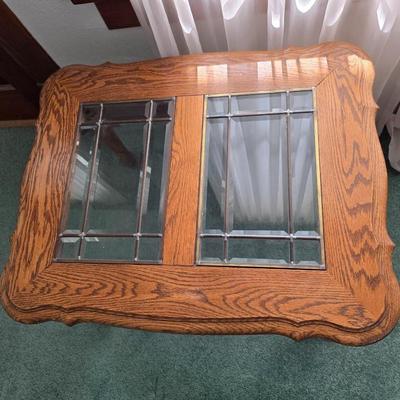 Vintage solid oak coffee table featuring a decorative, beveled, and leaded glass top insert and elegant curved or "ball and...