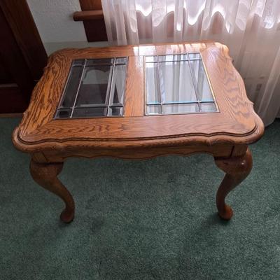 Vintage solid oak coffee table featuring a decorative, beveled, and leaded glass top insert and elegant curved or "ball and...
