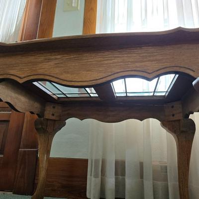 Vintage solid oak coffee table featuring a decorative, beveled, and leaded glass top insert and elegant curved or "ball and...