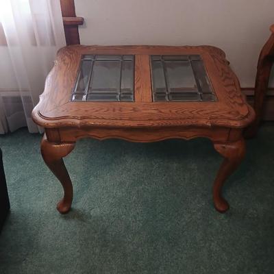 Vintage solid oak coffee table featuring a decorative, beveled, and leaded glass top insert and elegant curved or "ball and...