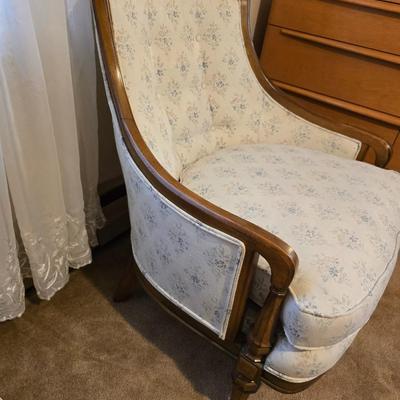 late 1960s armchair with a walnut frame and light-colored floral upholstery.