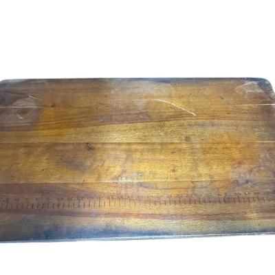 Sale Photo Thumbnail #284: This antique sewing table has a yardstick stamped into the wood. The table may need some minor repair. It opens and closes as expected. Measurement: 36”W. [CS]