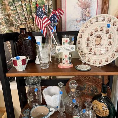 Sale Photo Thumbnail #33: Dishes, tins, glassware, books, custom curtains, mirror, silverware, framed art, etc
****Table, table cloth, plastic shelf, 2 wooden shelves, plate stands not included)****