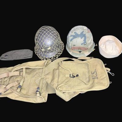 Sale Photo Thumbnail #317: Includes two Korean/Vietnam Era helmets with liners, a USMC flight cap, a USN "Dixie Cup" hat, and a WWII Era Haversack. Total of five pieces. Age related wear. [JP]