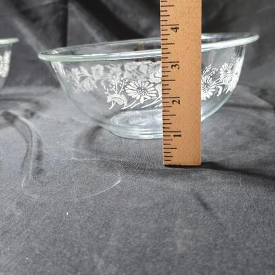 Three vintage Pyrex clear glass nesting mixing bowls in the "Colonial Mist" or "White Lace" pattern.