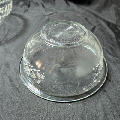 Three vintage Pyrex clear glass nesting mixing bowls in the "Colonial Mist" or "White Lace" pattern.