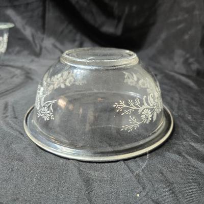 Three vintage Pyrex clear glass nesting mixing bowls in the "Colonial Mist" or "White Lace" pattern.