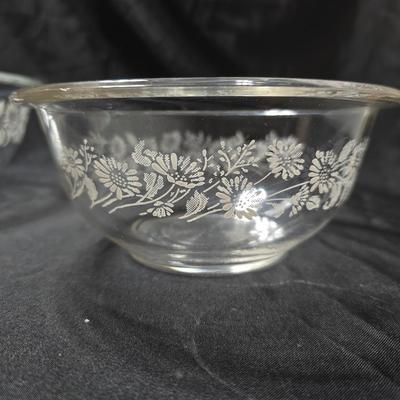 Three vintage Pyrex clear glass nesting mixing bowls in the "Colonial Mist" or "White Lace" pattern.