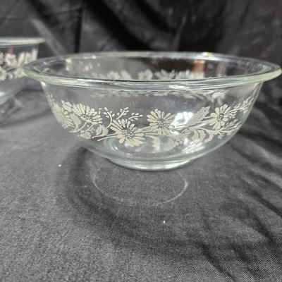 Three vintage Pyrex clear glass nesting mixing bowls in the "Colonial Mist" or "White Lace" pattern.