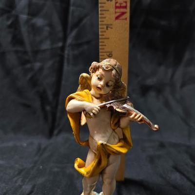 Vintage Fontanini Depose Italy cherub figurine, one standing and playing a violin, the other reclining with a floral garland.