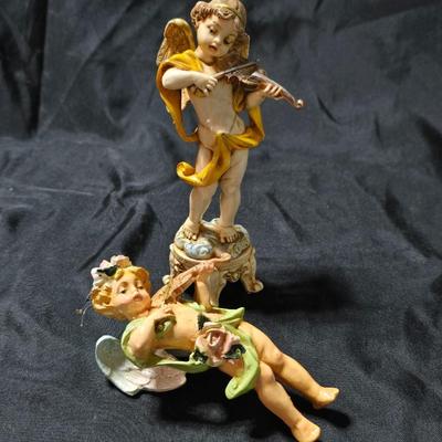 Vintage Fontanini Depose Italy cherub figurine, one standing and playing a violin, the other reclining with a floral garland.