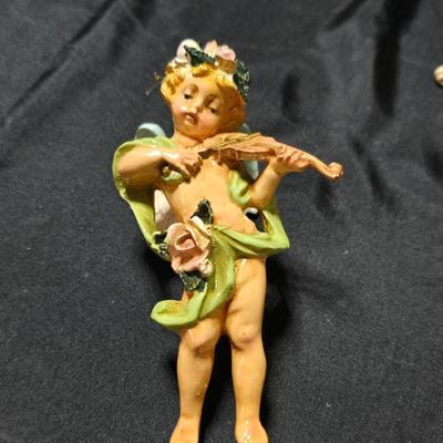 Vintage Fontanini Depose Italy cherub figurine, one standing and playing a violin, the other reclining with a floral garland.