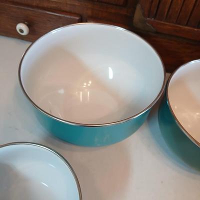 Three nesting enamel mixing bowls and a glass Pyrex measuring cup