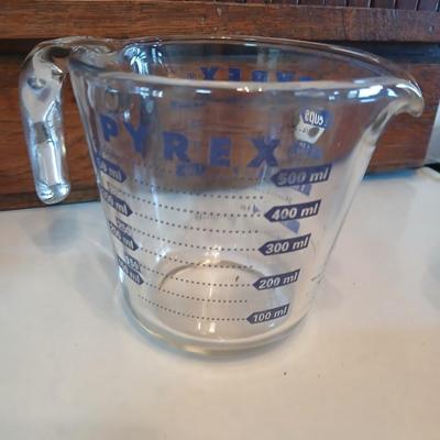 Three nesting enamel mixing bowls and a glass Pyrex measuring cup