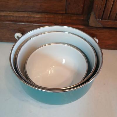 Three nesting enamel mixing bowls and a glass Pyrex measuring cup