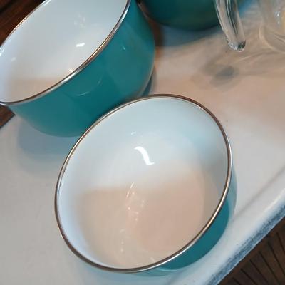 Three nesting enamel mixing bowls and a glass Pyrex measuring cup