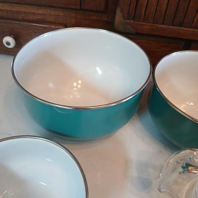 Three nesting enamel mixing bowls and a glass Pyrex measuring cup