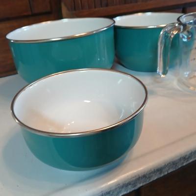 Three nesting enamel mixing bowls and a glass Pyrex measuring cup