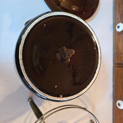 Pfaltzgraff Gourmet Brown drip glaze covered casserole dish with a metal and wood warming stand.