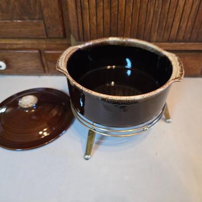 Pfaltzgraff Gourmet Brown drip glaze covered casserole dish with a metal and wood warming stand.