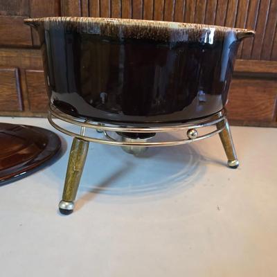 Pfaltzgraff Gourmet Brown drip glaze covered casserole dish with a metal and wood warming stand.