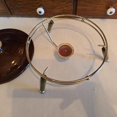 Pfaltzgraff Gourmet Brown drip glaze covered casserole dish with a metal and wood warming stand.