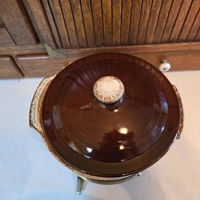 Pfaltzgraff Gourmet Brown drip glaze covered casserole dish with a metal and wood warming stand.