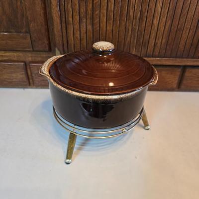 Pfaltzgraff Gourmet Brown drip glaze covered casserole dish with a metal and wood warming stand.