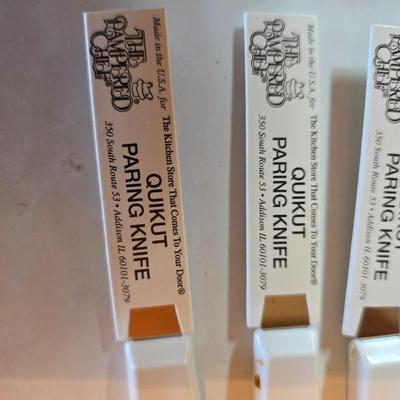 Wooden cutting board with 5 Pampered Chef Quickut Paring Knives and an Alaskan Ulu knife