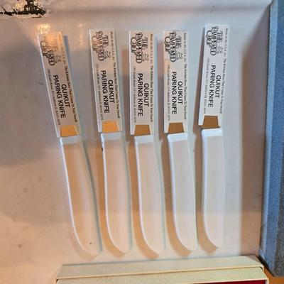 Wooden cutting board with 5 Pampered Chef Quickut Paring Knives and an Alaskan Ulu knife