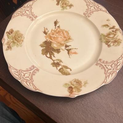 Sale Photo Thumbnail #24: Beautiful antique Ohme Silesia porcelain plate featuring soft blush and ivory roses with a delicate embossed border and gilt accents.
Backstamps include the Ohme Silesia green shield and blue crown Silesia marks, used between 1892–1918. A fine example o