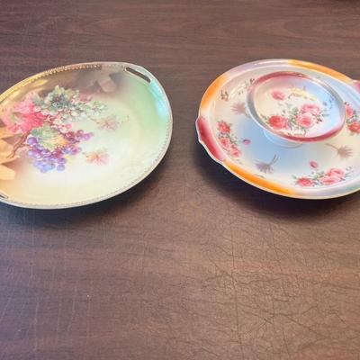 Sale Photo Thumbnail #54: Charming pair of early 20th-century German porcelain serving plates featuring hand-painted florals and grapevine motifs with gold trim.
Includes:
1️⃣ Porcelain handled tray with purple grape cluster design – marked “Jäger & Co Bavaria Germany,”