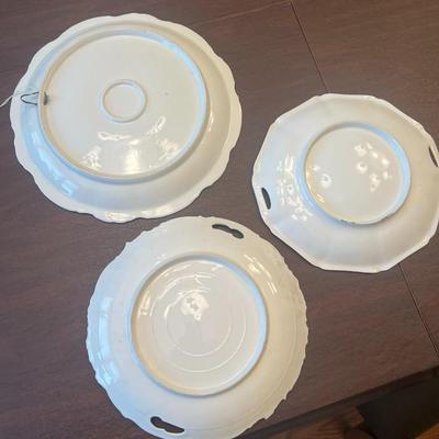 Sale Photo Thumbnail #63: Beautiful trio of early 20th-century European porcelain display plates, each showcasing hand-painted or transfer-decorated artistry and fine embossed detailing.
Included:
1.	Game Bird Plate – embossed rim with scalloped edges, featuring a detailed pheas