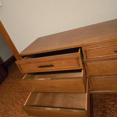 Mid-century modern walnut nine-drawer lowboy dresser by Dixie Furniture Co. with a matching mirror.
