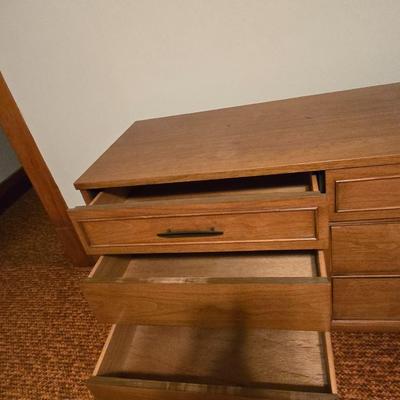 Mid-century modern walnut nine-drawer lowboy dresser by Dixie Furniture Co. with a matching mirror.