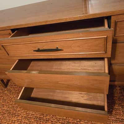 Mid-century modern walnut nine-drawer lowboy dresser by Dixie Furniture Co. with a matching mirror.