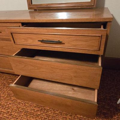 Mid-century modern walnut nine-drawer lowboy dresser by Dixie Furniture Co. with a matching mirror.