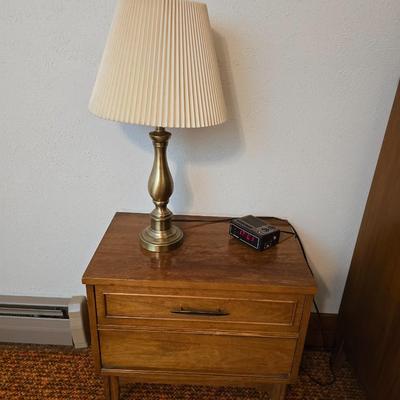Mid-century modern walnut nightstand or side table by Dixie Furniture Co. with brass lamp and an alarm clock