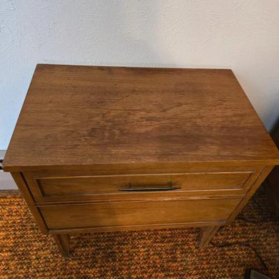 Mid-century modern walnut nightstand or side table by Dixie Furniture Co. with brass lamp and an alarm clock