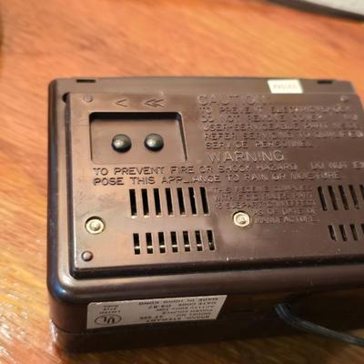 Mid-century modern walnut nightstand or side table by Dixie Furniture Co. with brass lamp and an alarm clock