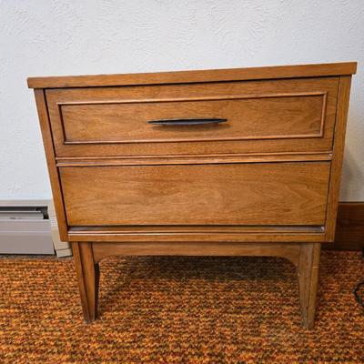 Mid-century modern walnut nightstand or side table by Dixie Furniture Co. with brass lamp and an alarm clock