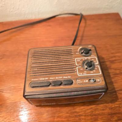 Mid-century modern walnut nightstand or side table by Dixie Furniture Co. with brass lamp and an alarm clock