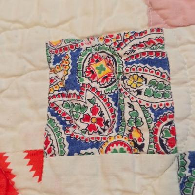 Handmade patchwork quilt featuring a scrappy nine-patch block design and a light purple border. Postage Stamp quilt Irish Chain pattern