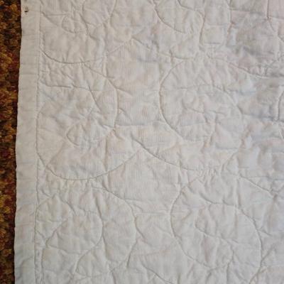 Handmade patchwork quilt featuring a scrappy nine-patch block design and a light purple border. Postage Stamp quilt Irish Chain pattern