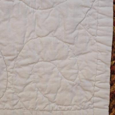 Handmade patchwork quilt featuring a scrappy nine-patch block design and a light purple border. Postage Stamp quilt Irish Chain pattern
