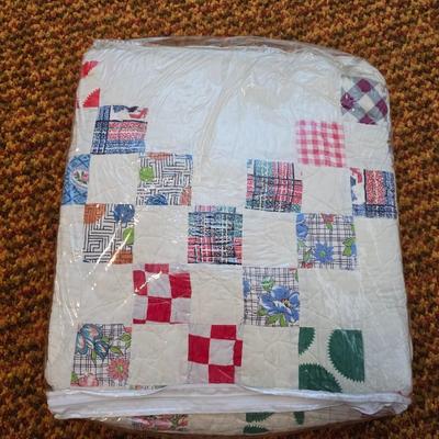 Handmade patchwork quilt featuring a scrappy nine-patch block design and a light purple border. Postage Stamp quilt Irish Chain pattern