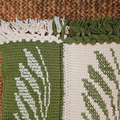 handmade green and white crochet blanket with a leaves pattern and fringed edges with a knitted reverse cat themed throw