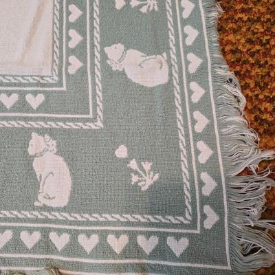 handmade green and white crochet blanket with a leaves pattern and fringed edges with a knitted reverse cat themed throw