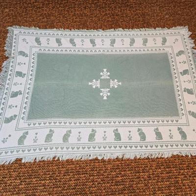 handmade green and white crochet blanket with a leaves pattern and fringed edges with a knitted reverse cat themed throw